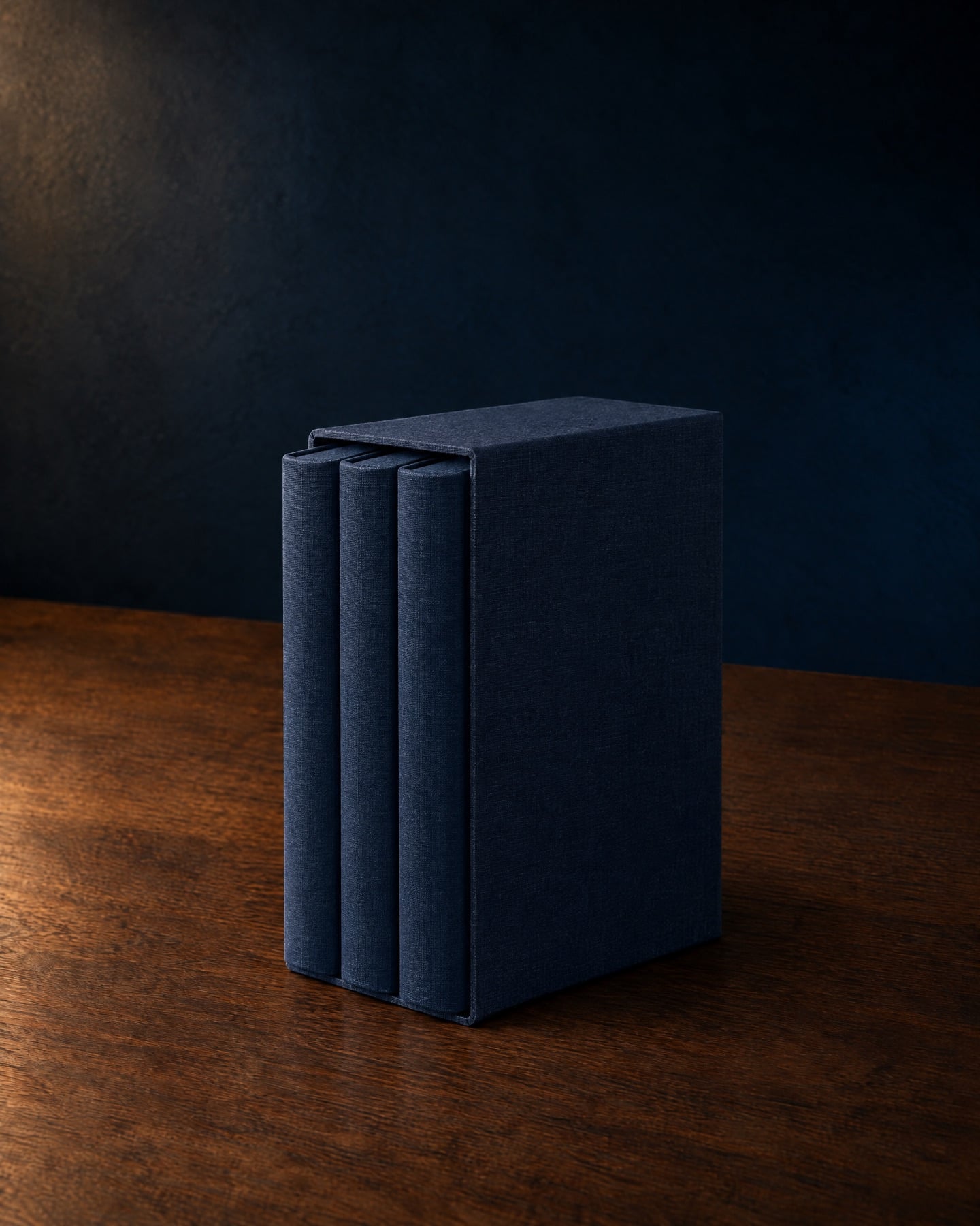 Three midnight-blue clothbound books in a matching slipcase
