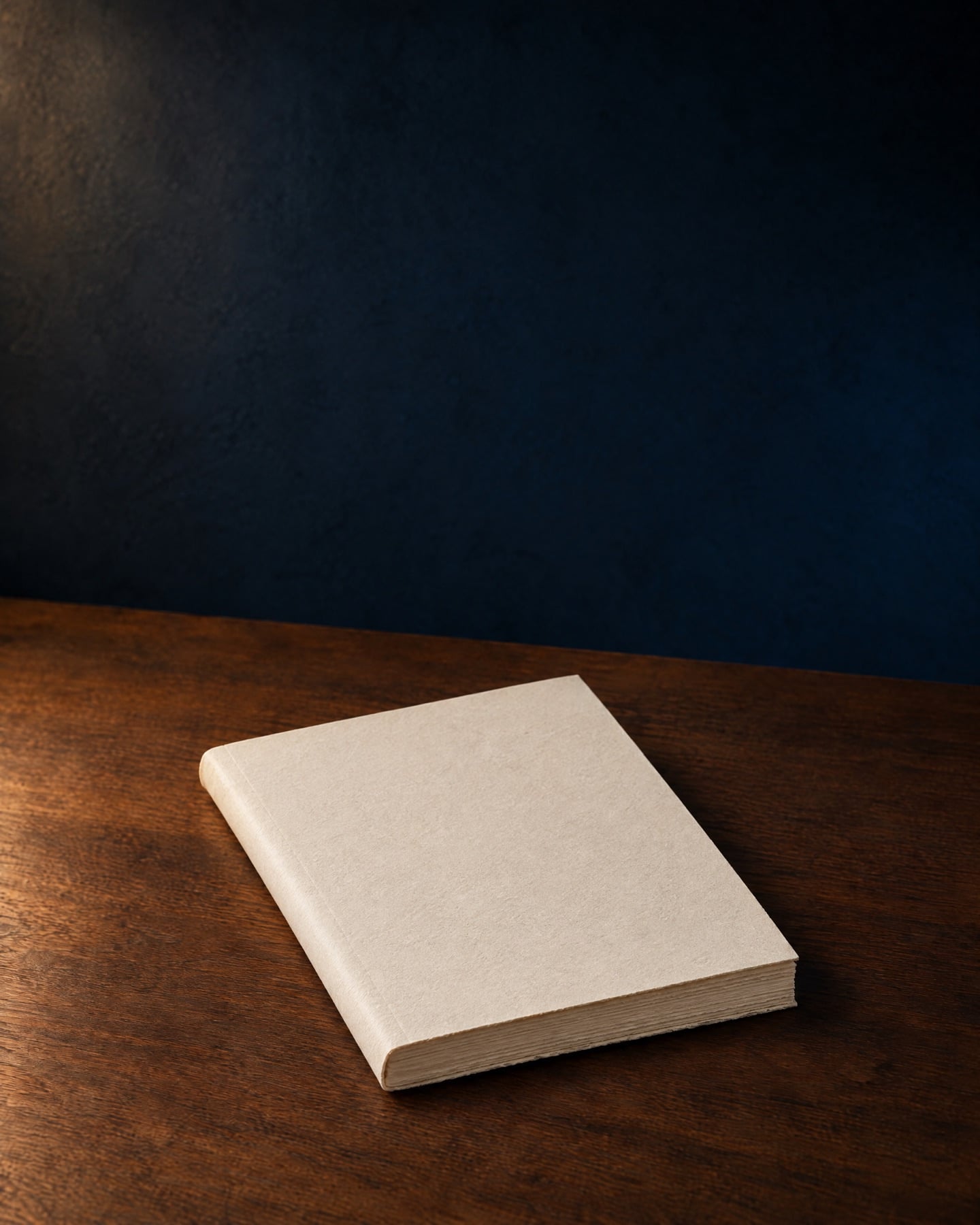 A cream softcover book on a walnut table